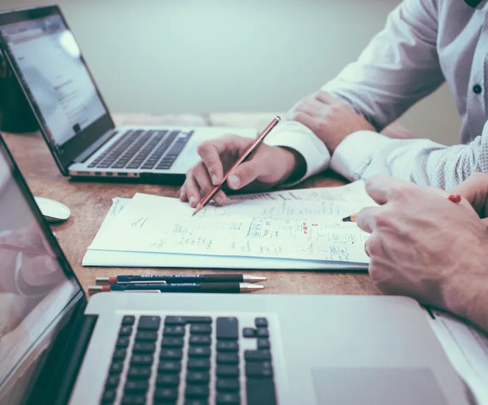 People working on laptops and writing things down